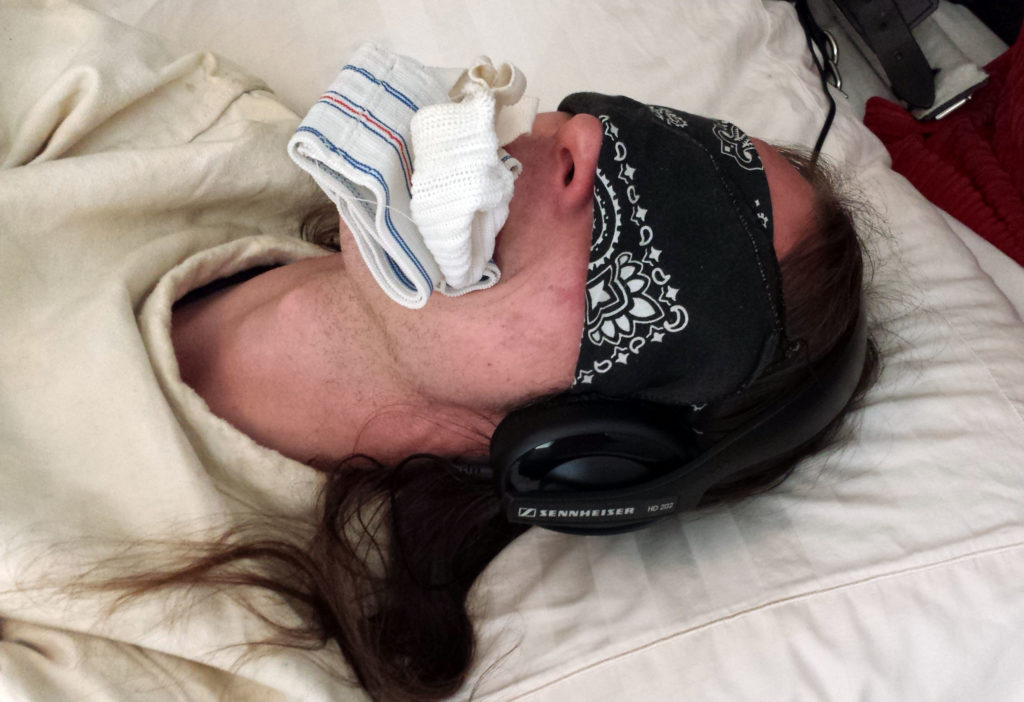 Jock gagged, blindfolded, headphones on.