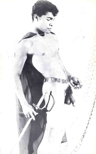 Johnny Menendez nude, with a sword, with his foreskin skinned back.