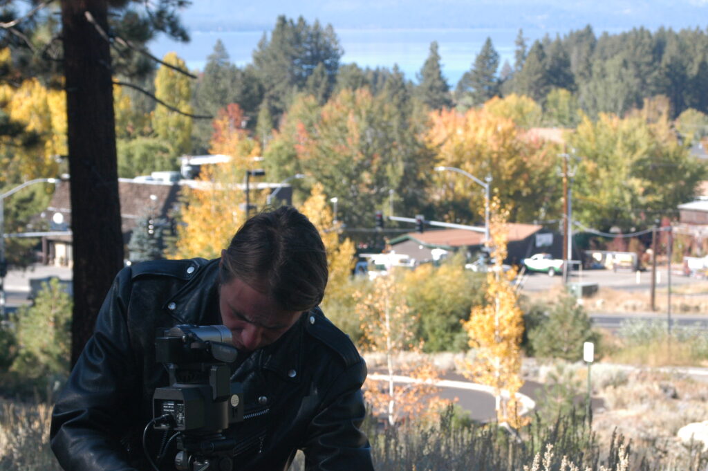 Joe V. photo of Jack Drago in a leather jacket fiddling with hys camera.